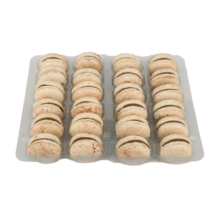 24 cappuccino macarons with white shells and cocoa powder dusting on top.