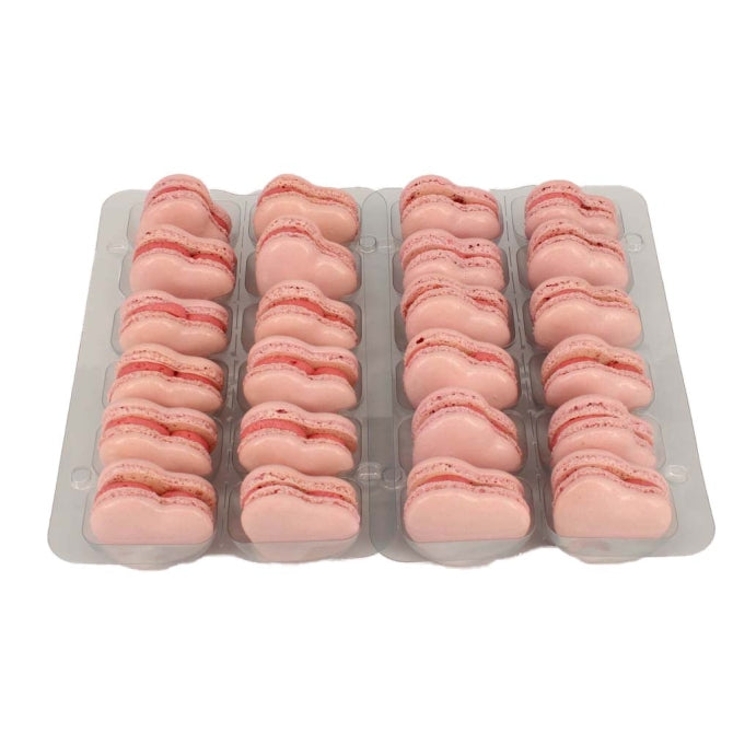 A tray of pink heart-shaped raspberry macarons arranged neatly in rows.