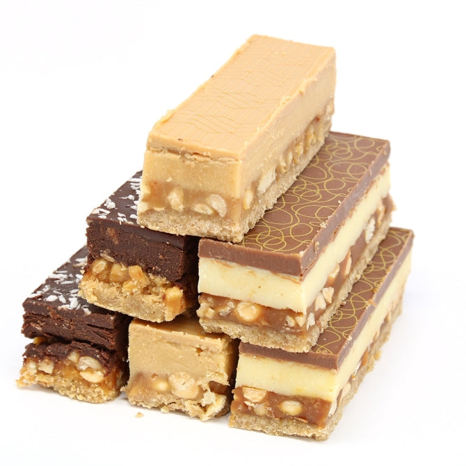 Side view of six Macarons and More chocolate bars showing multiple distinct layers of biscuit, caramel, ganache and chocolate