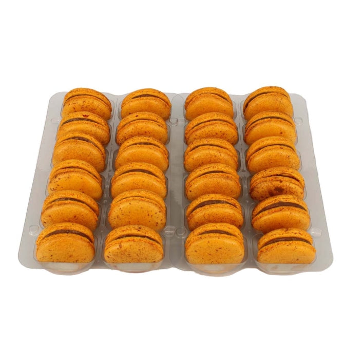 A tray of orange macarons with chocolate filling, arranged in rows.