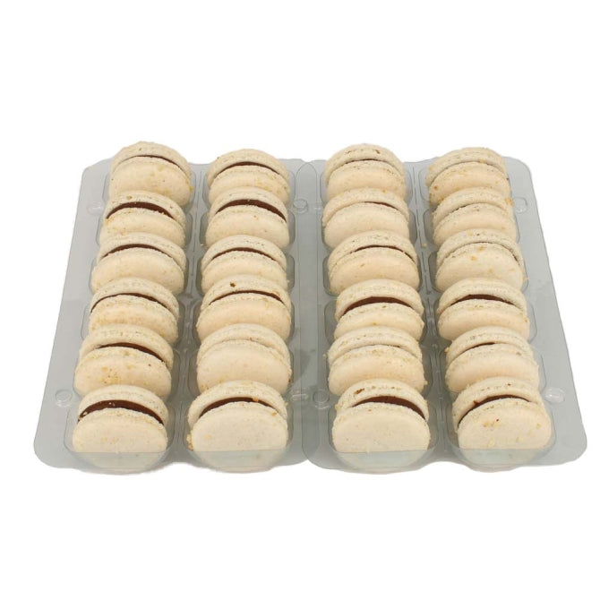 A tray of white praline macarons with pale white shells and a chocolate filling, sprinkled with finely chopped roasted hazelnuts.