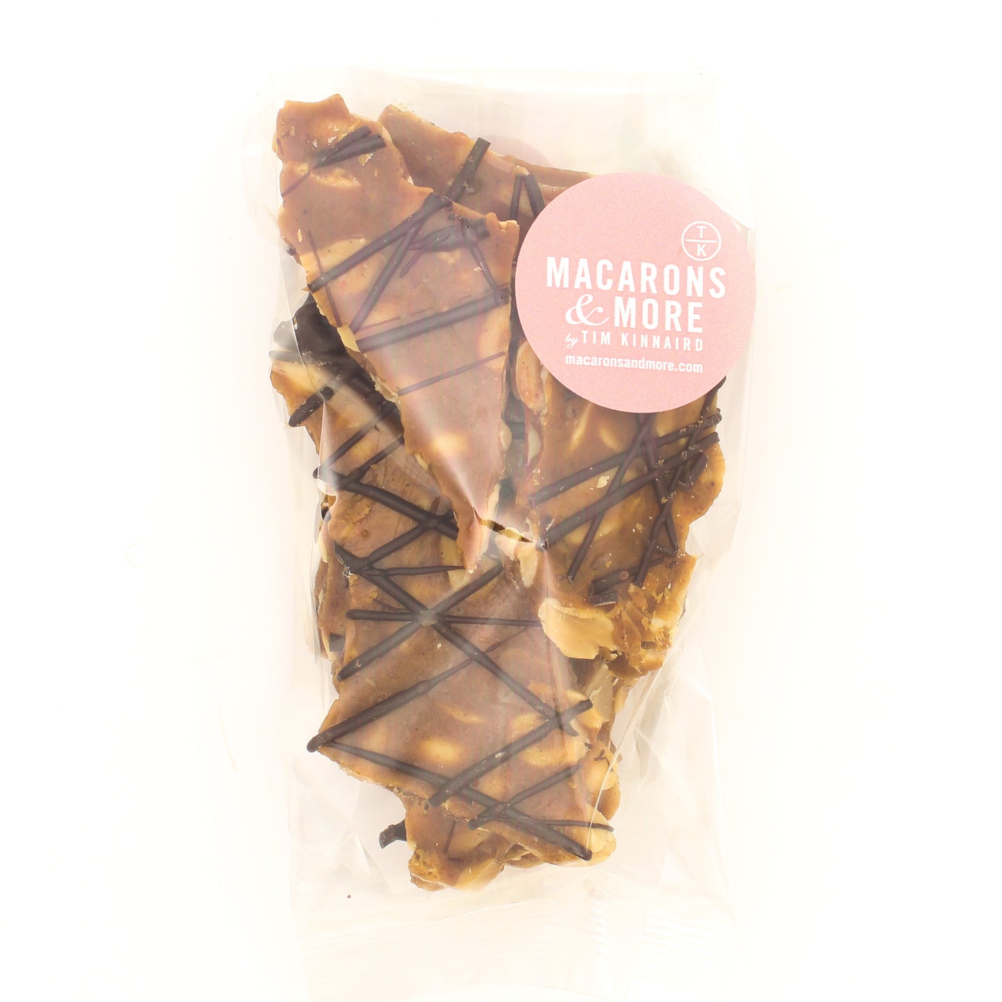 Spiced Peanut Brittle drizzled with chocolate and packaged in a clear bag.