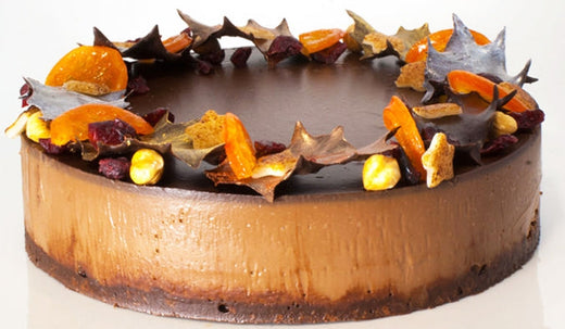 Large Chocolate Delice with three clear layers, topped with orange slices, nuts and chocolate leaves