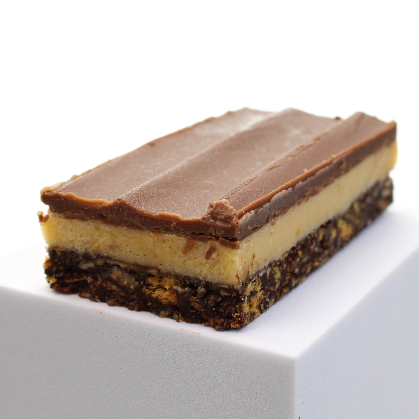 Nanaimo bar showing three distinct layers. Choose this homemade bar for your chocolate gift box.