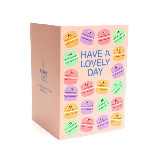 Greeting card with colourful macaron illustrations on a pink background and 'Have a Lovely Day'