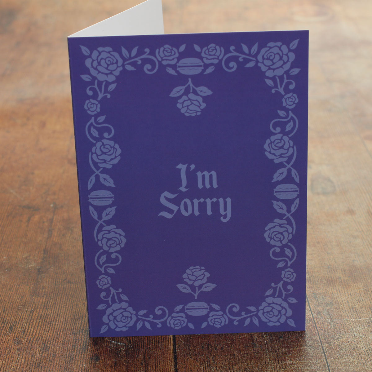 Purple card with floral border and 'I'm Sorry' text on a wooden surface