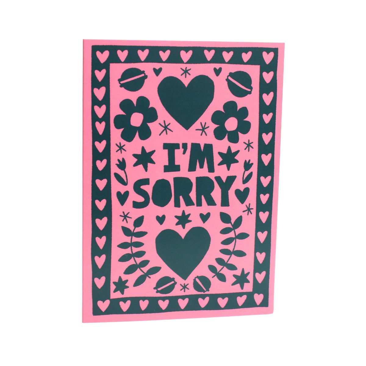 Card with 'I'm Sorry' text on a pink background with black hearts and flowers and macarons 