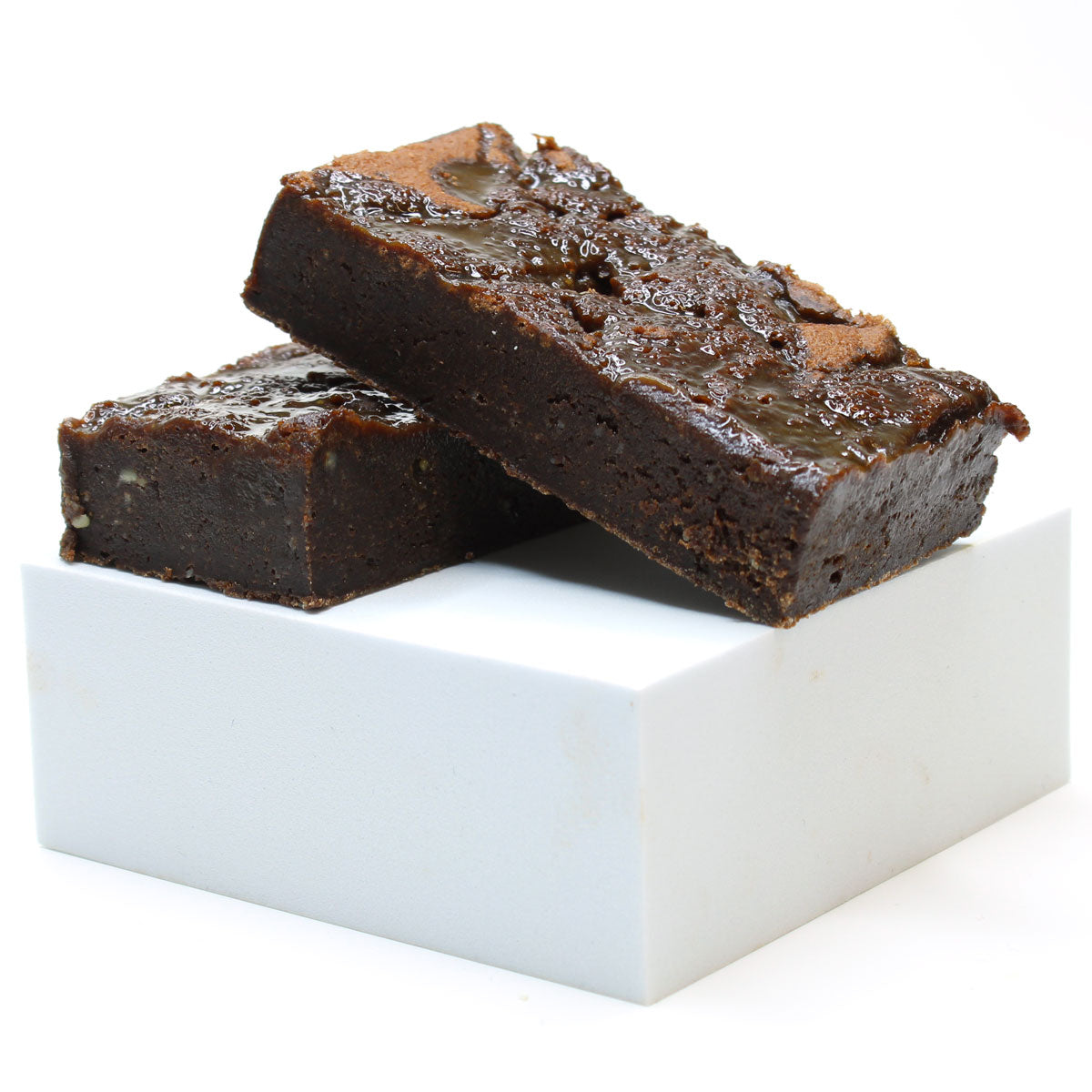 Two brownies on a white square platform with a white background