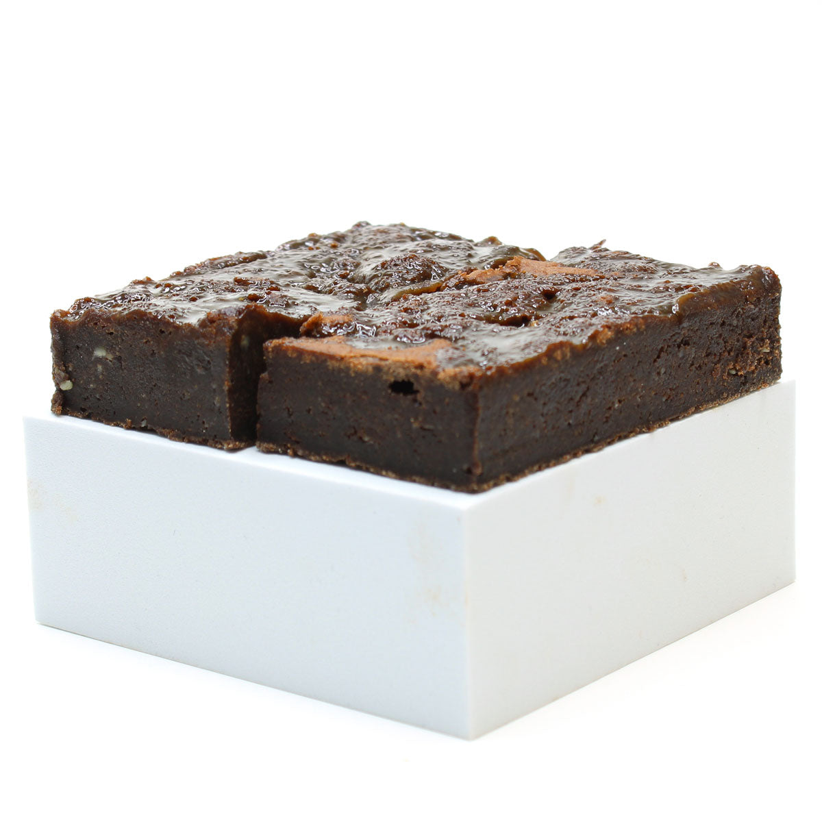 Two salted caramel brownies in front of a white background 