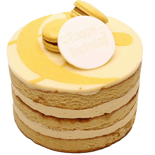 A Salted Caramel cake with multiple layers, toped with icing, macarons and a curly ampersand design and a 'Happy Birthday' plaque.