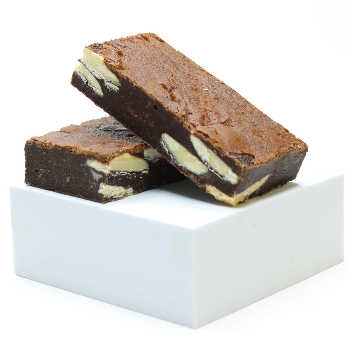 Two white chocolate brownies stack on a white box