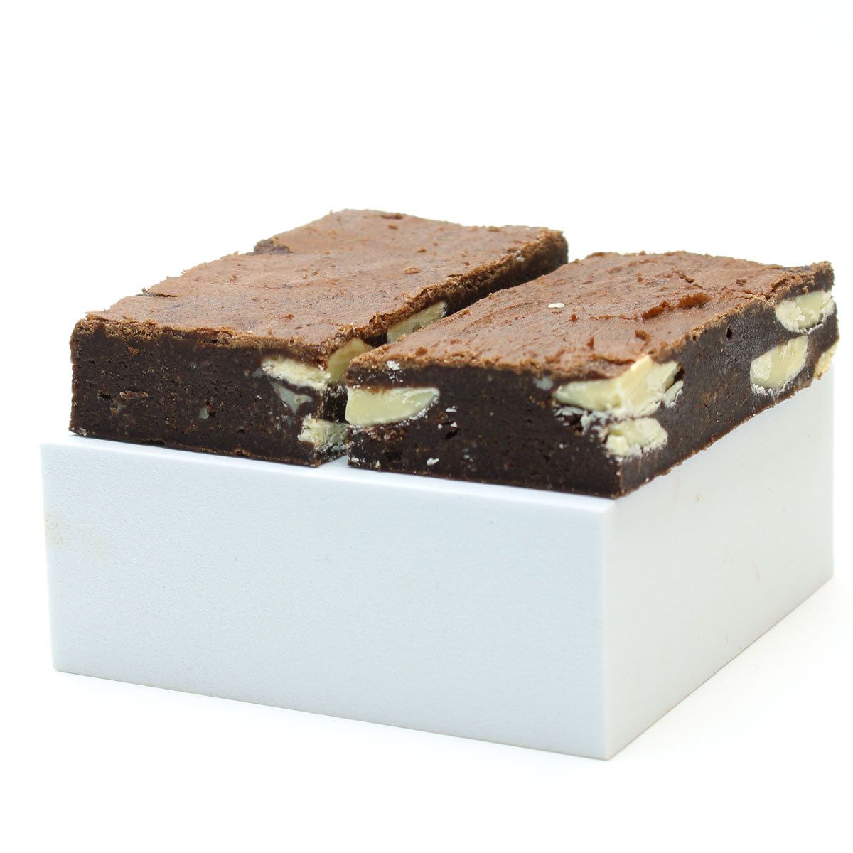 Two white chocolate chip brownies on a white box