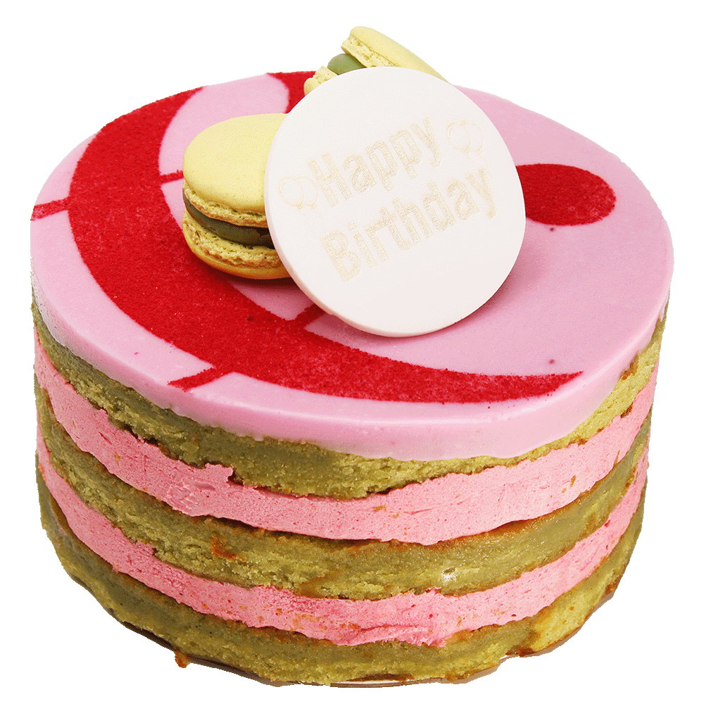 A Raspberry & Pistachio cake with multiple layers, toped with icing, macarons and a curly ampersand design and a 'Happy Birthday' plaque.
